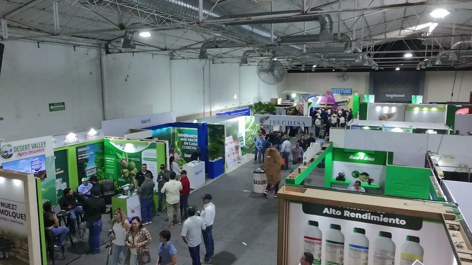 Pasillo de expo con stands y visitantes desde el dron